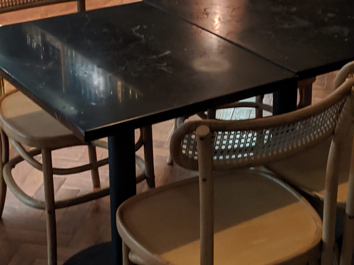 Black marble surface showing etching before restoration